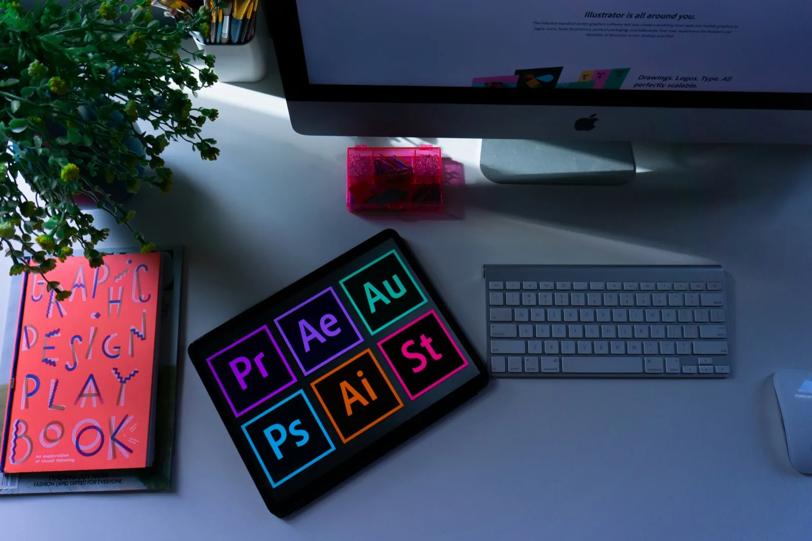 Grafikdesign-Arbeitsplatz mit Tablet, Adobe-Apps und Desktop-Computer