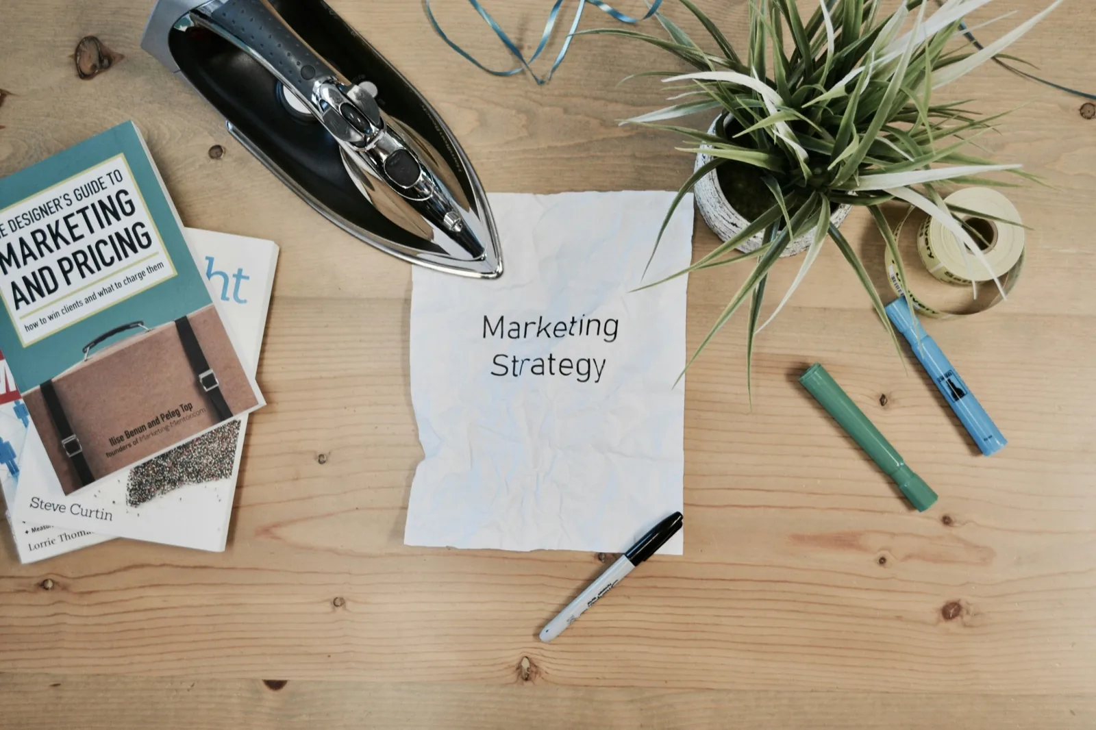Marketingstrategie mit Notizen, Buch und Schreibtischmaterial